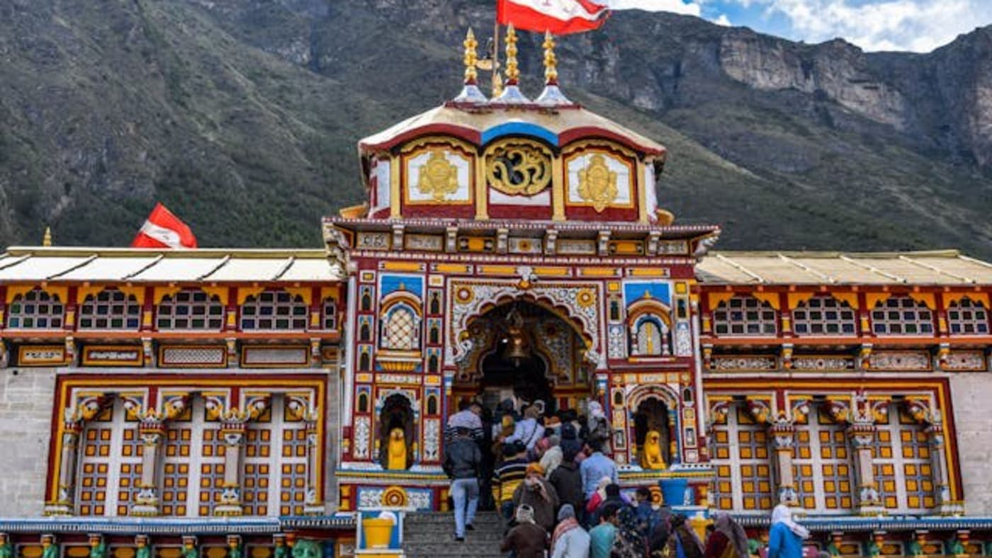 Pilgrims entering the colorful Badrinath Temple in the Himalayas during the sacred Do Dham blessings journey.