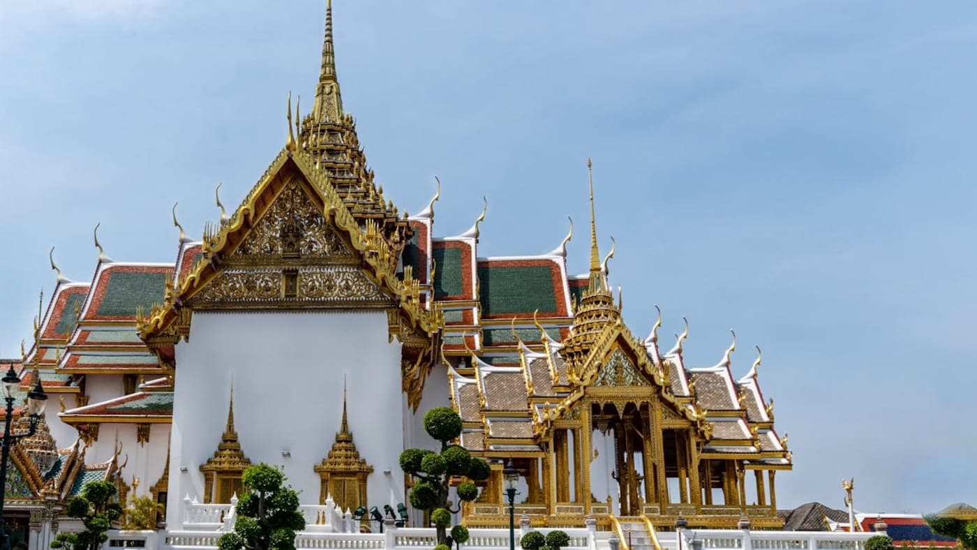 Grand Palace temple complex with golden roofs and ornate architecture in Bangkok, Thailand.