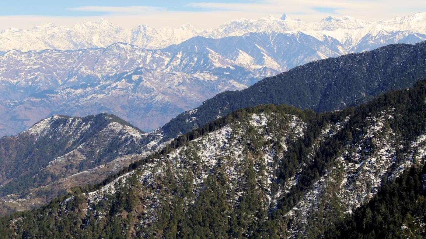 Snow covered Himalayan peaks and pine forest hills in scenic Dalhousie, Himachal Pradesh.
