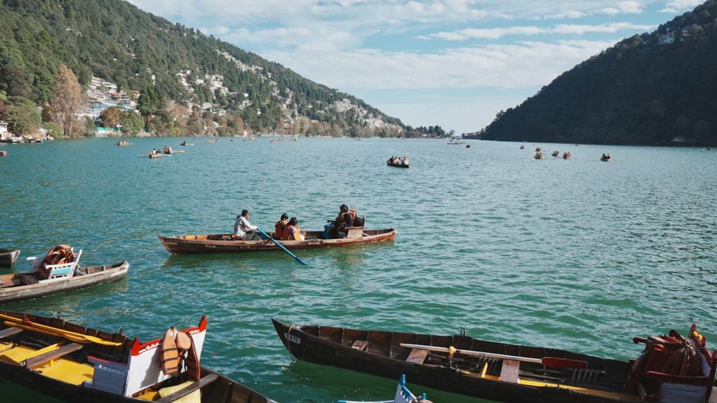 Boating on Naini Lake surrounded by forested hills and scenic town views in Nainital, Uttarakhand.