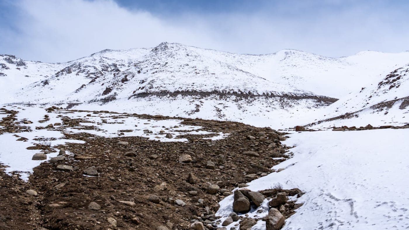 Snow covered rugged mountains and rocky valley landscape in the high altitude region of Ladakh.