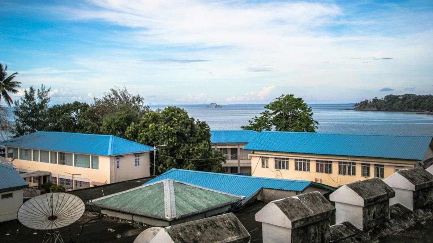 Blue-roof buildings overlooking the sea at Cellular Jail in Port Blair, Andaman with calm ocean and tropical skyline