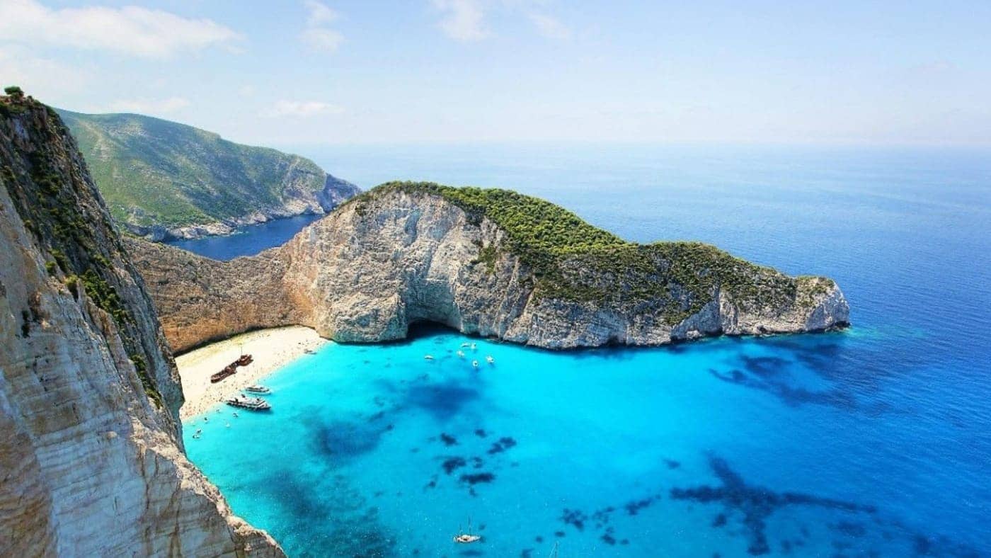 Dramatic limestone cliffs surrounding a turquoise bay and beach in the Andaman and Nicobar Islands.