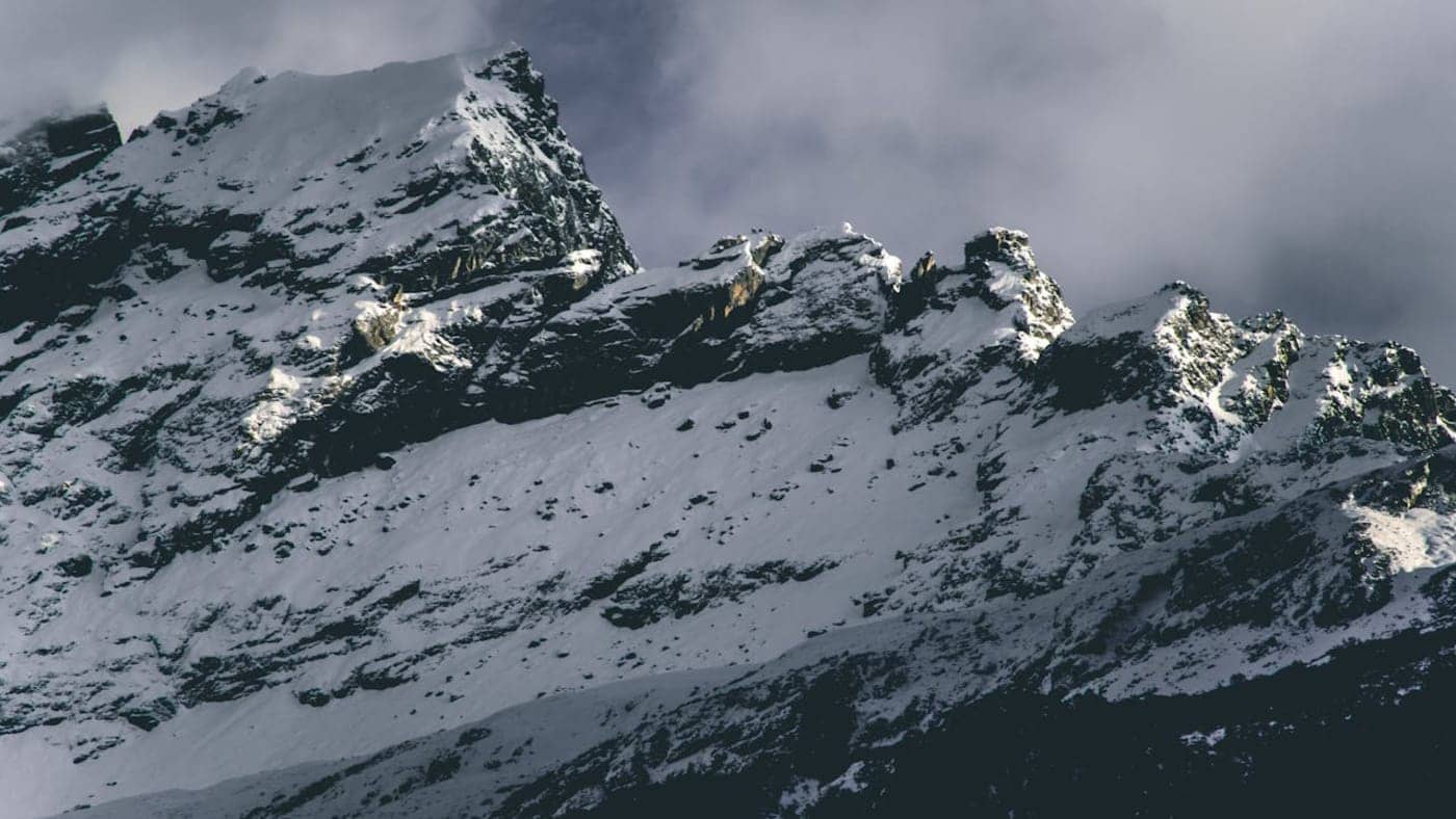 Snow-covered mountain peaks in Sikkim with rugged ridges and clouds hovering over the high altitude landscape