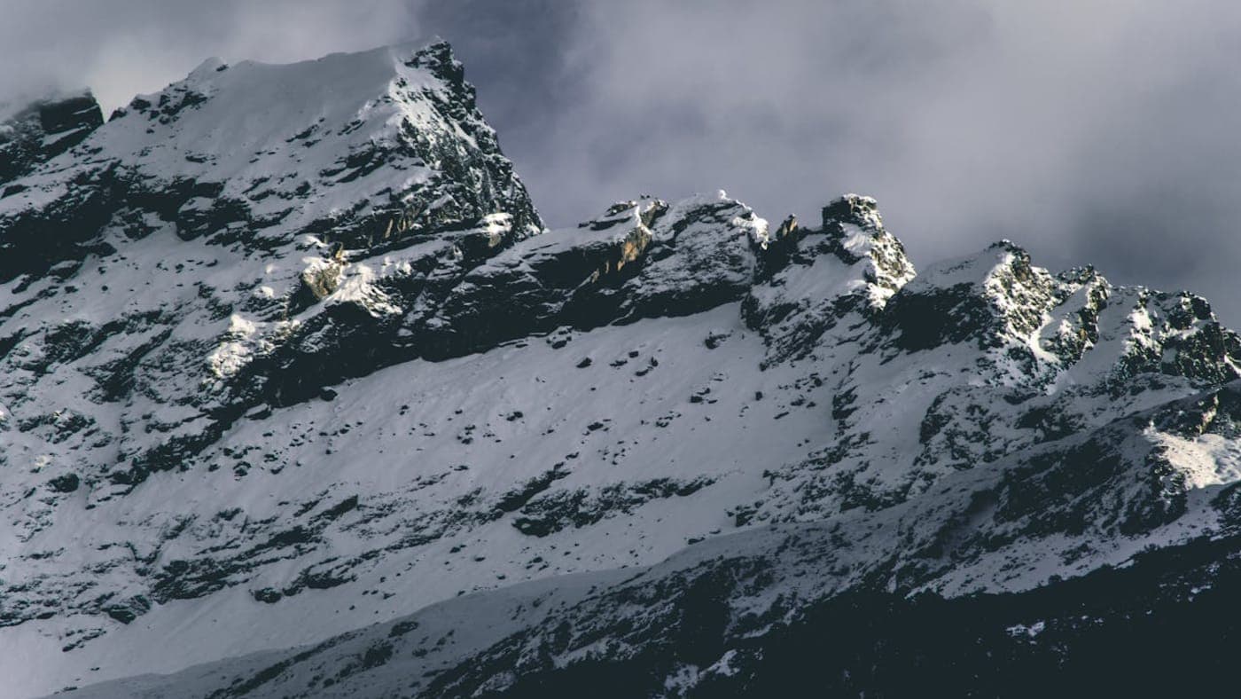 Snow-covered mountain peaks in Sikkim with rugged ridges and clouds hovering over the high altitude landscape
