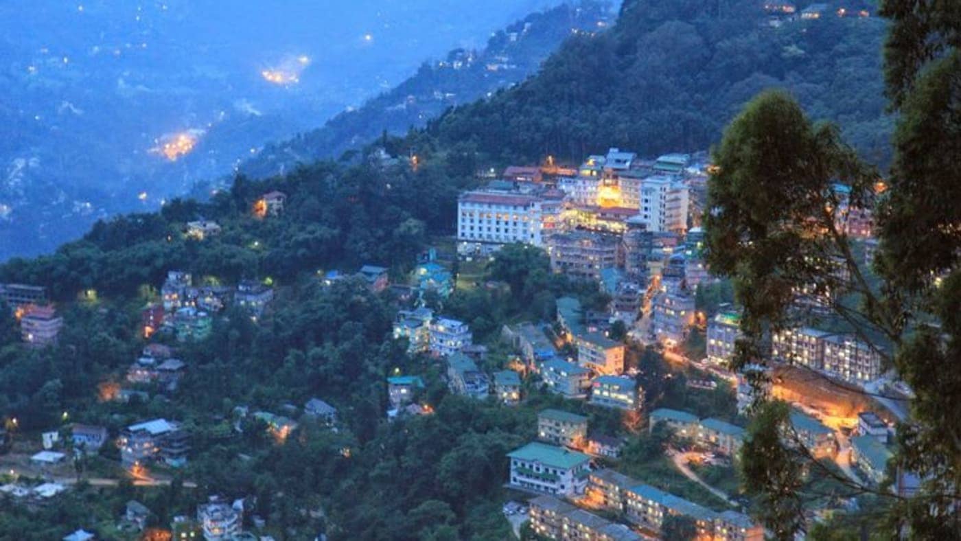 Evening view of Gangtok, Sikkim, surrounded by forested hills and glowing city lights